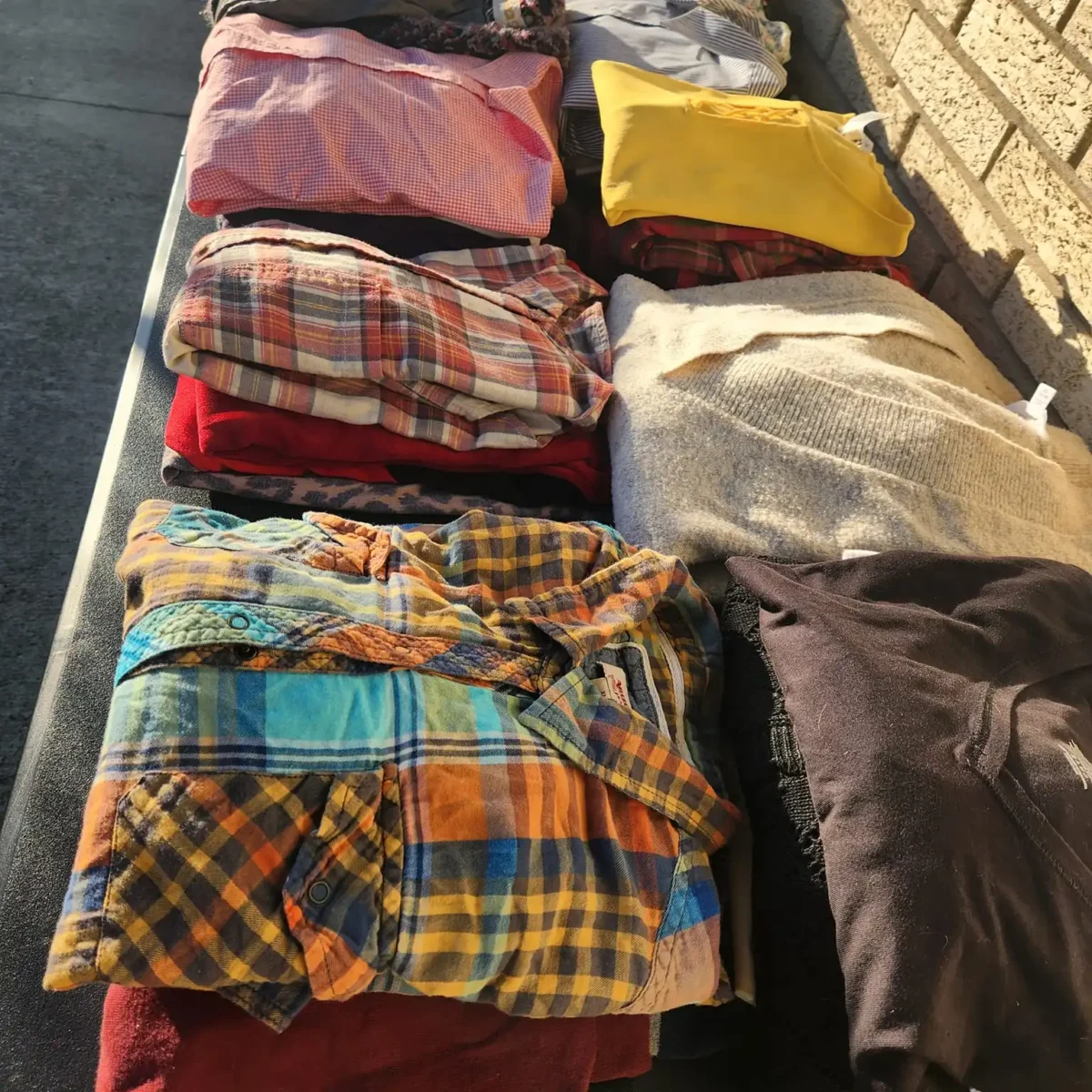 stacks of used clothing folded on a table
