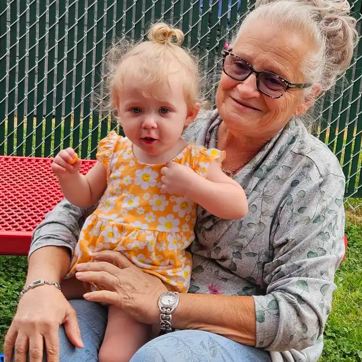 toddler girl sitting on grandma's lap
