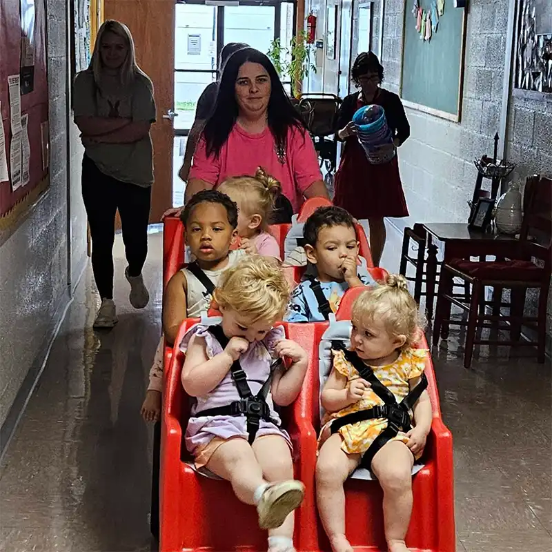 toddler children riding in a push cart