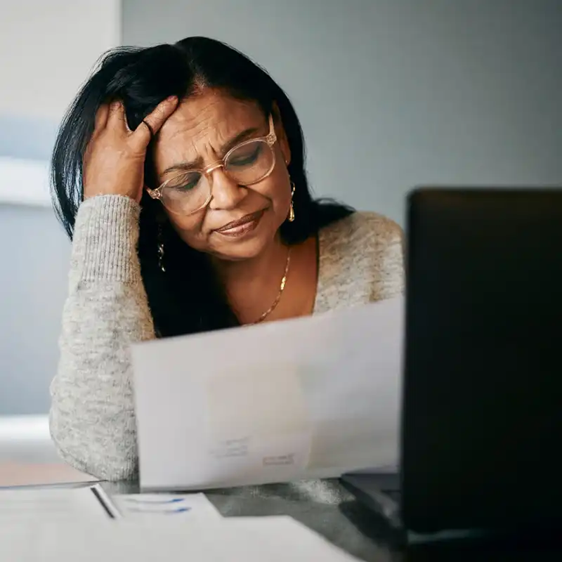 native american woman appearing worried while looking at her utility bills