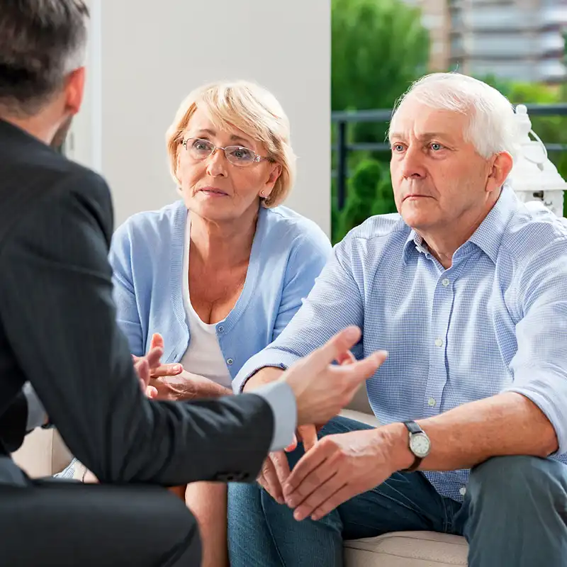 elderly couple listening to a Medicare consultant