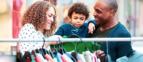 mother, father, and child picking out clothes