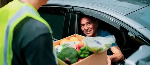 INCA working giving a box of food to a recipient