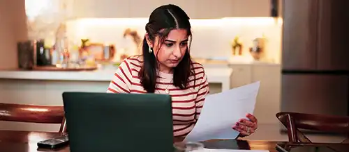 woman appearing troubled looking at utility bills
